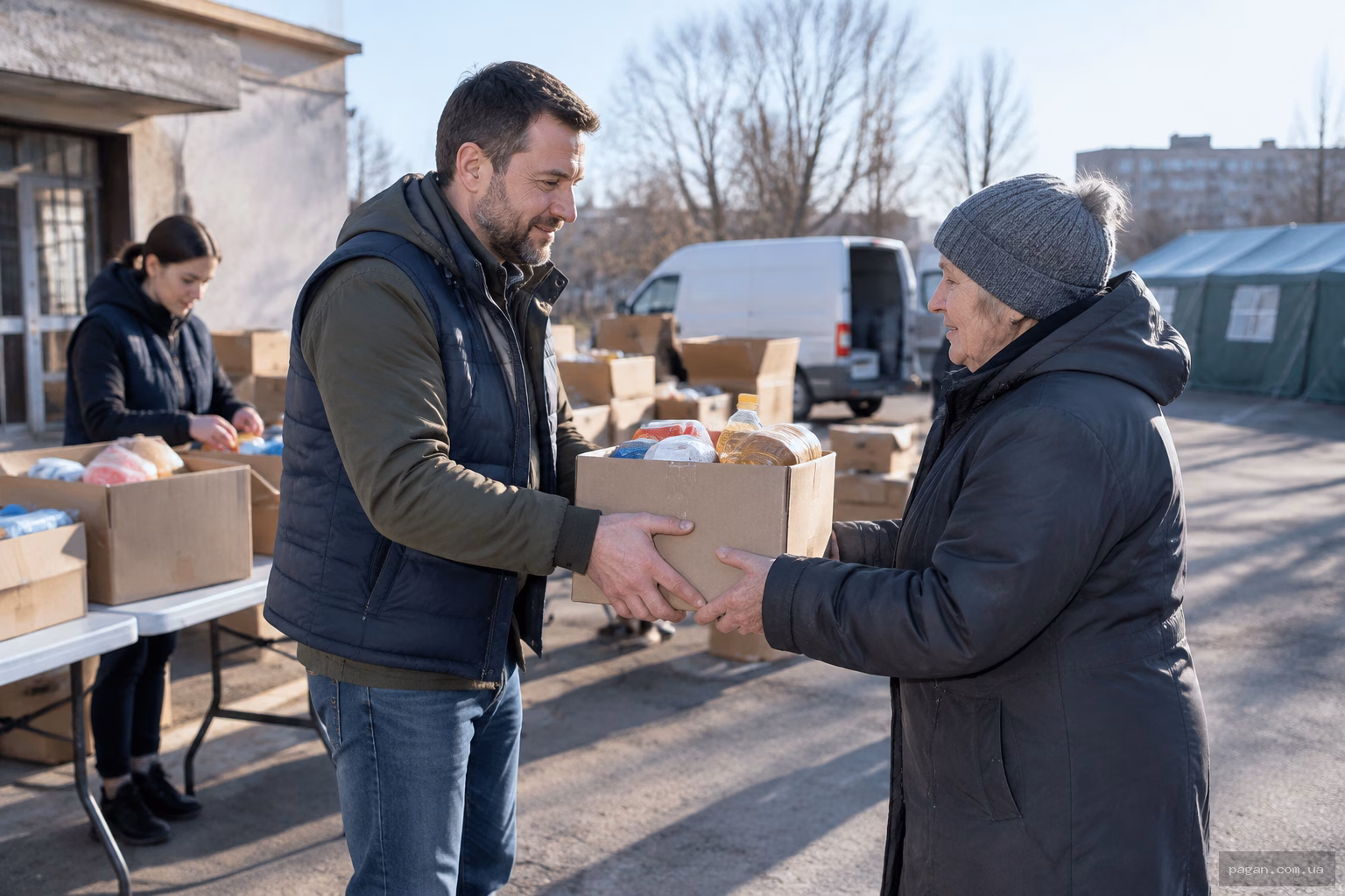 Чоловік передає продуктовий набір літній жінці в пункті допомоги громаді
