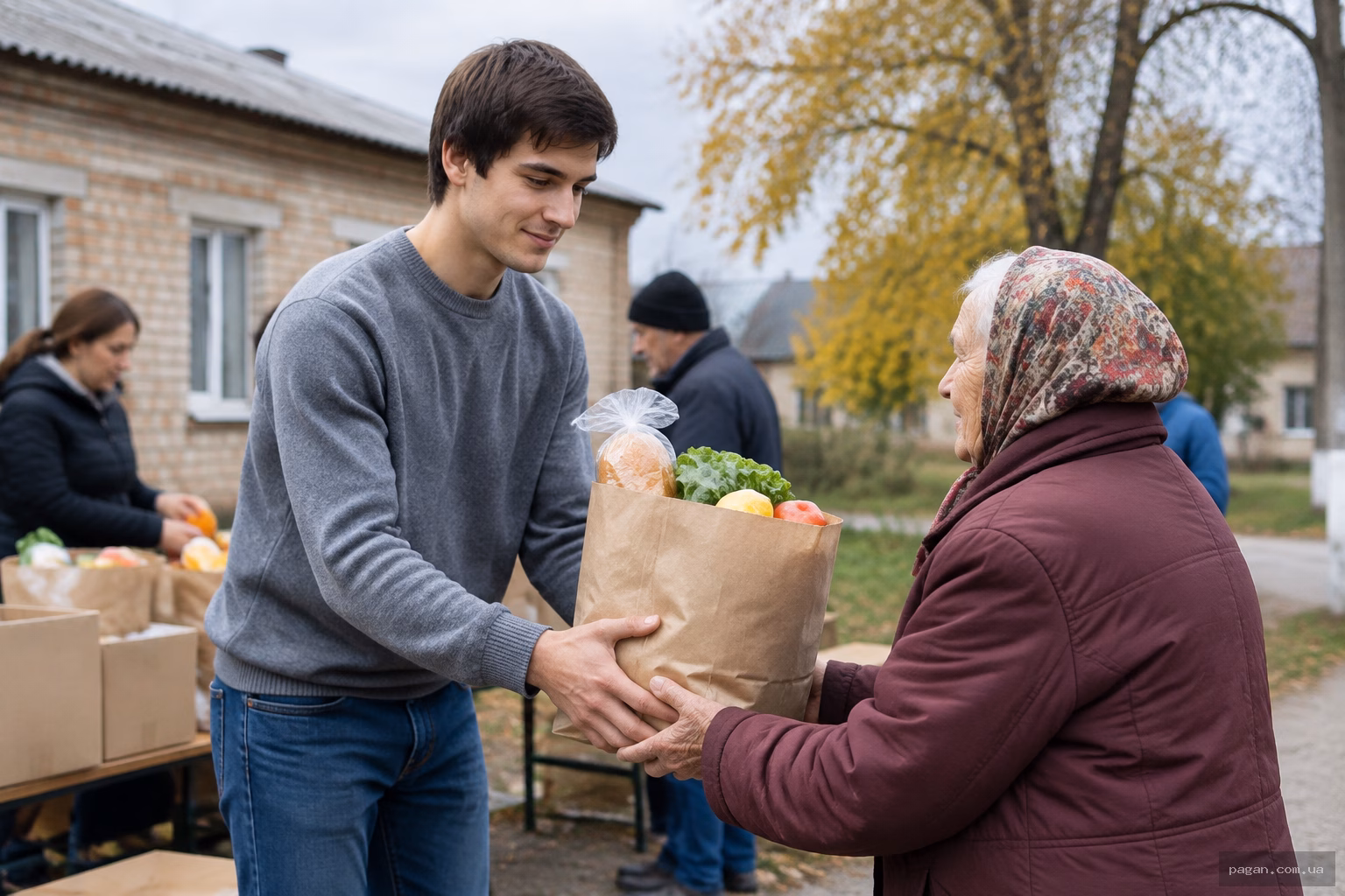 Молодий чоловік передає пакунок з продуктами літній жінці на подвір'ї