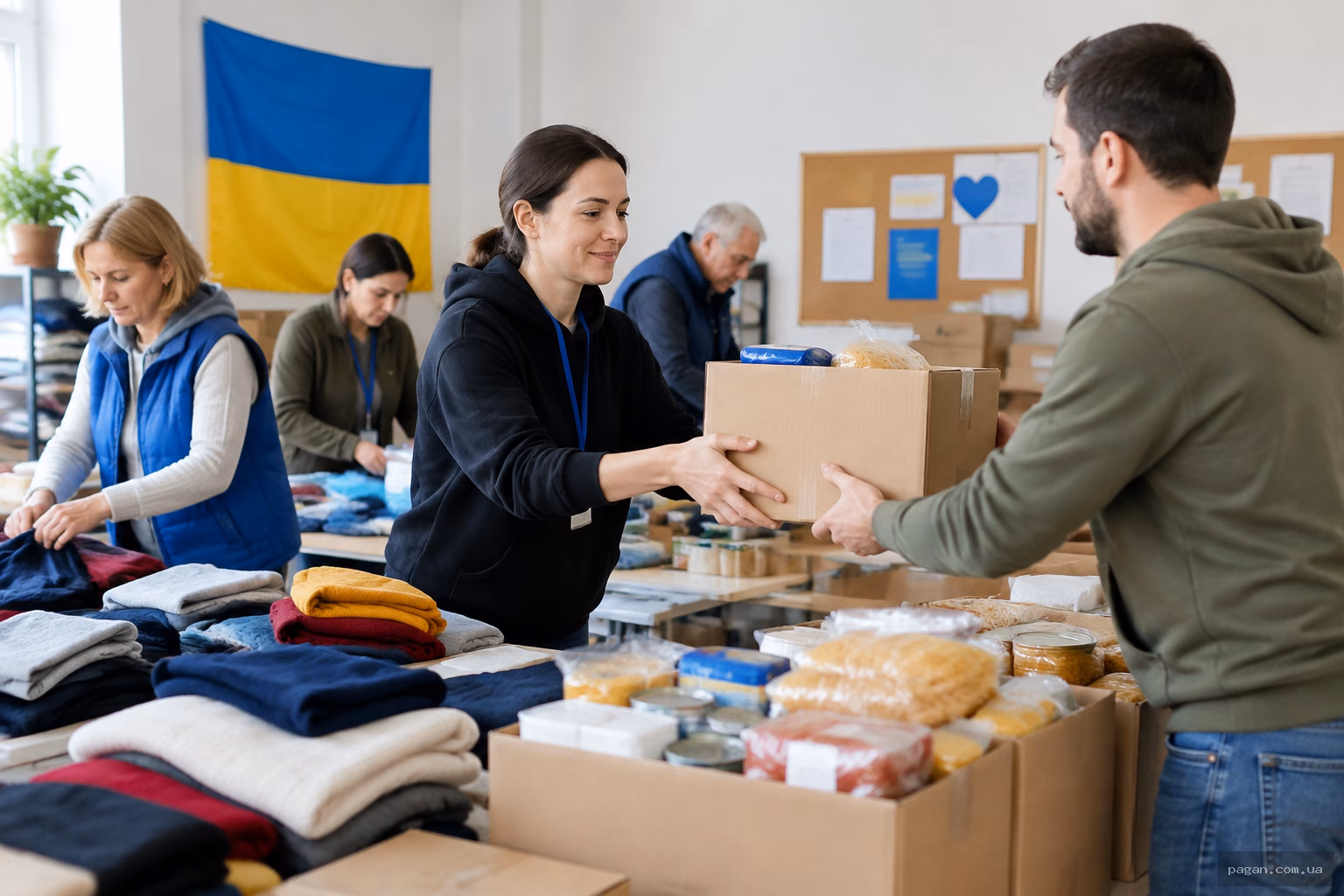 Волонтери в громадському центрі сортують речі та продуктові набори